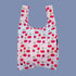A light pink and blue ombre nylon tote bag with a cherry print. 