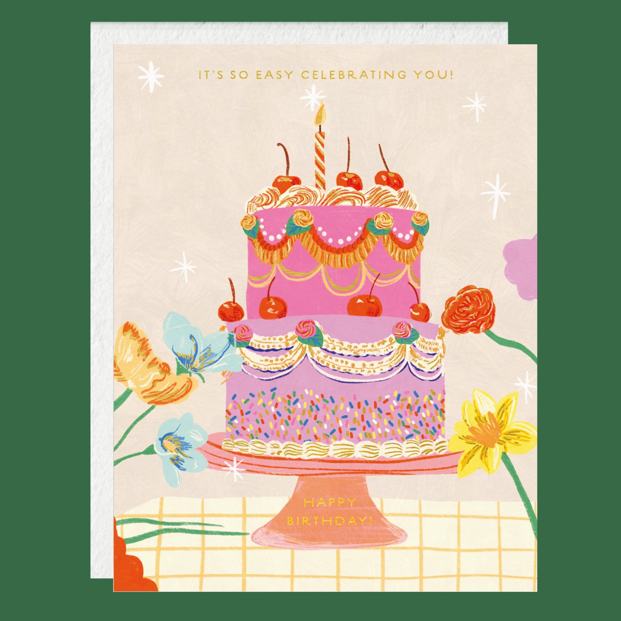 A square greeting card with a matching envelope, featuring an illustrated two-tier birthday cake with cherries, flowers, and the text 'IT'S SO EASY CELEBRATING YOU!' on a cream background.
