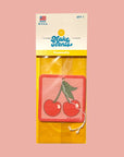 A square air freshener with a graphic of two cherries. 