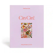 On a white background is a purple boxed puzzle with a colorful food and drink tablescape in the center along with orange text that reads, "Cin! Cin!".
