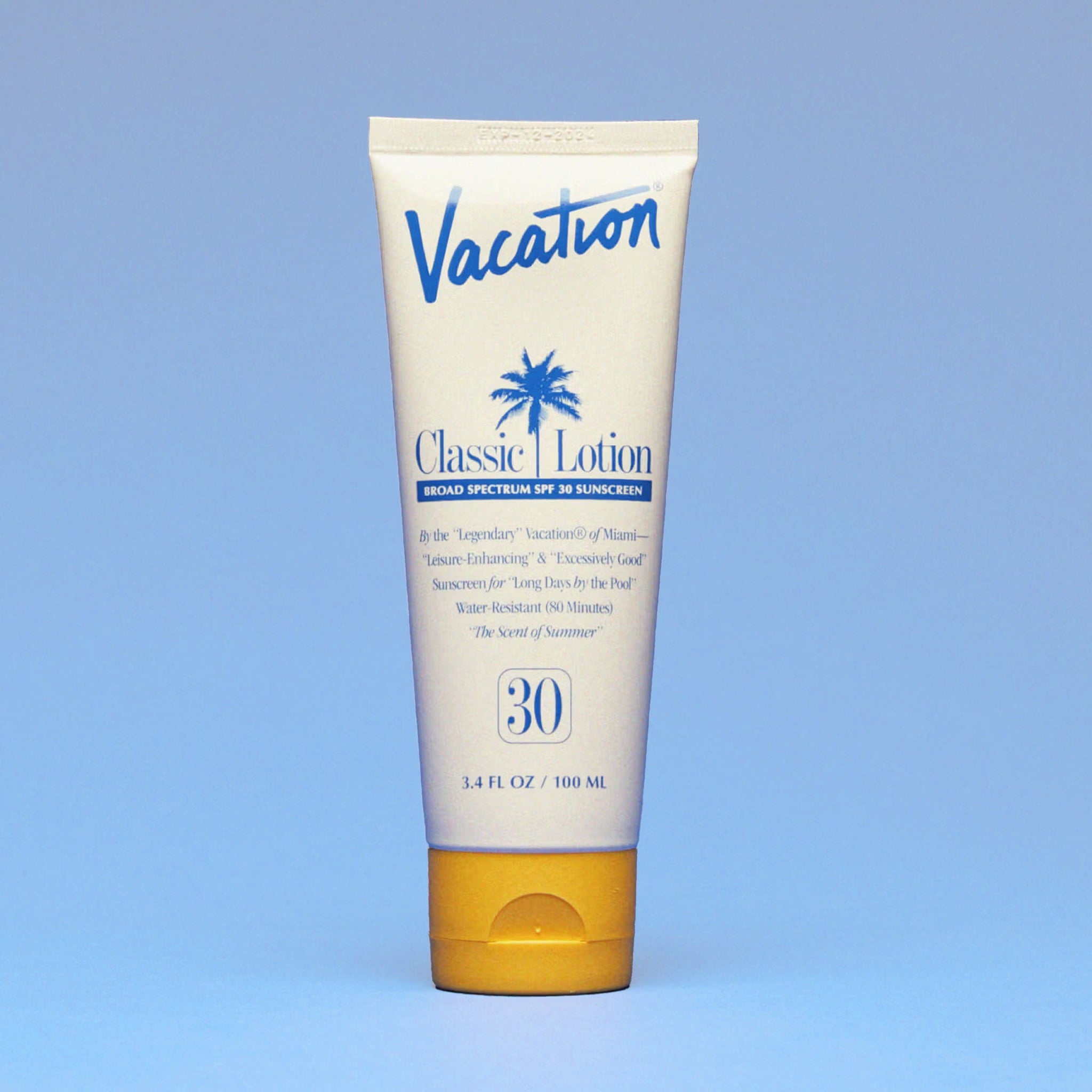 A white squeeze tube of sunscreen with a yellow lid and a blue text that reads, "Vacation Classic Lotion SPF 30" along with a blue palm design in the center.