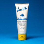 On a blue background is a white squeeze tube of sunscreen with a yellow lid and a blue text that reads, "Vacation Classic Lotion SPF 30" along with a blue palm design in the center.
