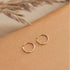 A pair of tiny gold hoops in three different sizes. Each pair sold separately. 