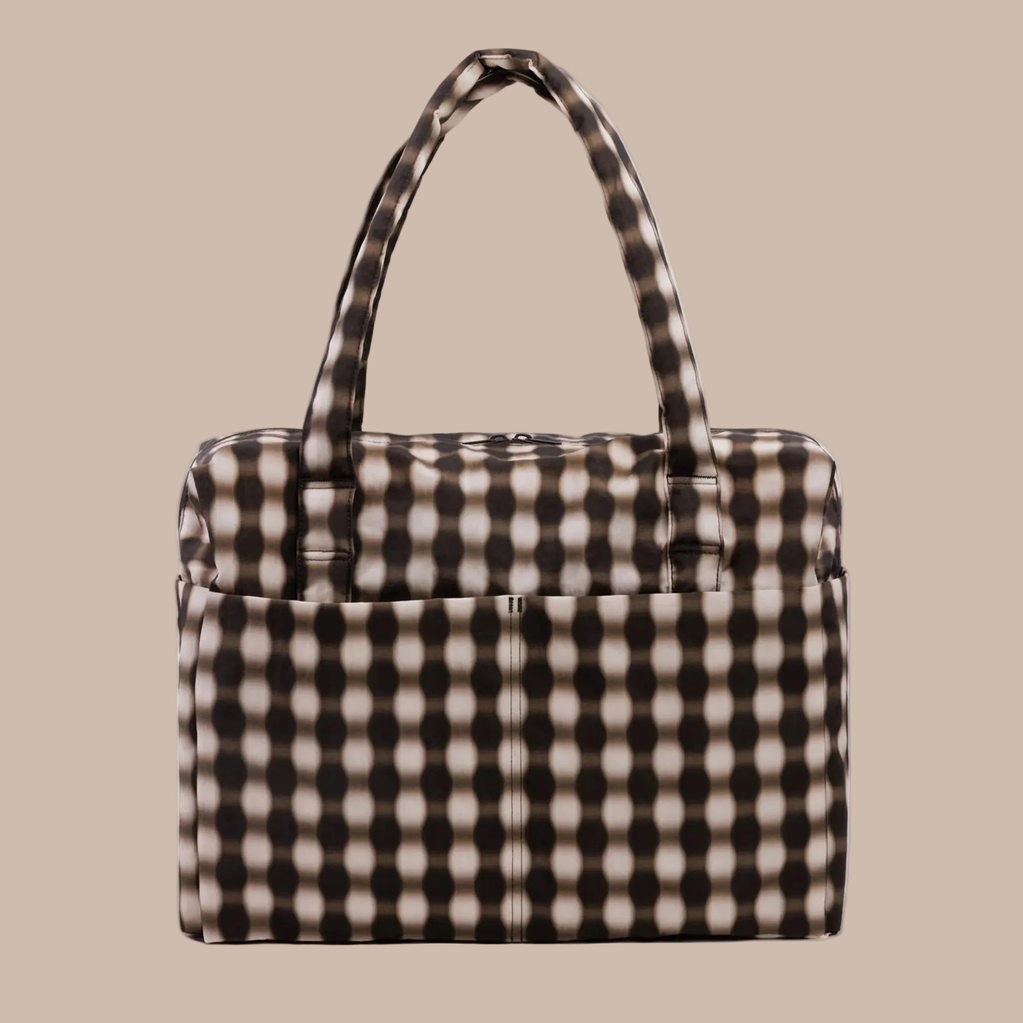 A blurred edge brown, black and tan gingham print nylon carry on tote. 