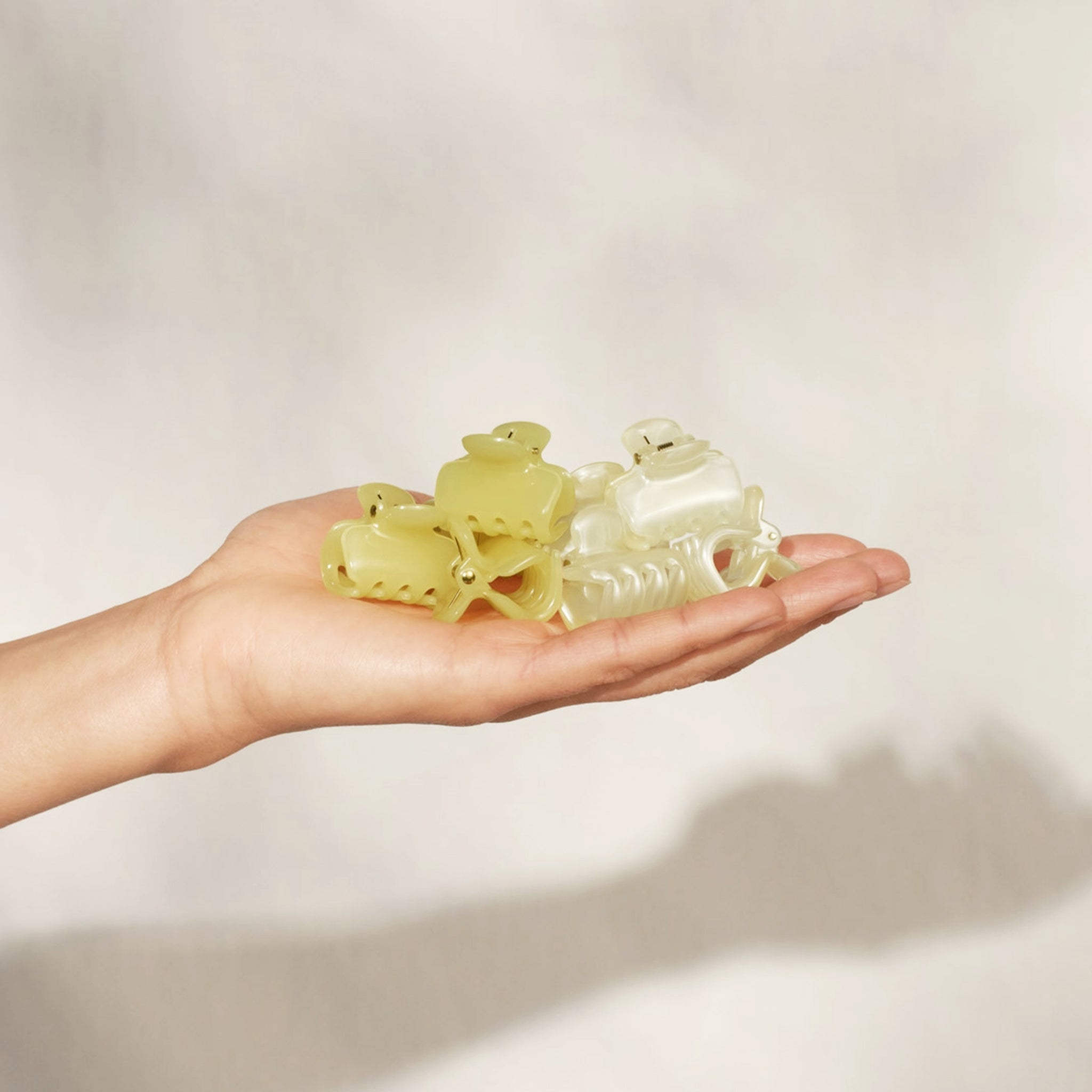 A set of yellow and neutral puffy small hair clips. 