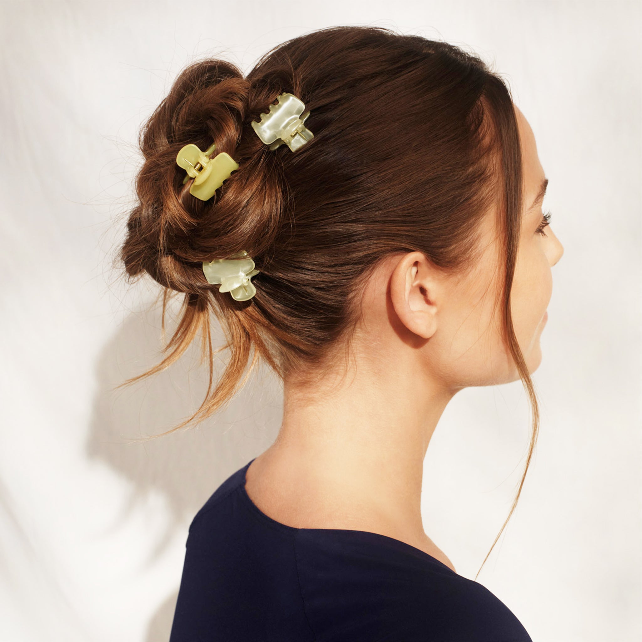 A set of yellow and neutral puffy small hair clips. 