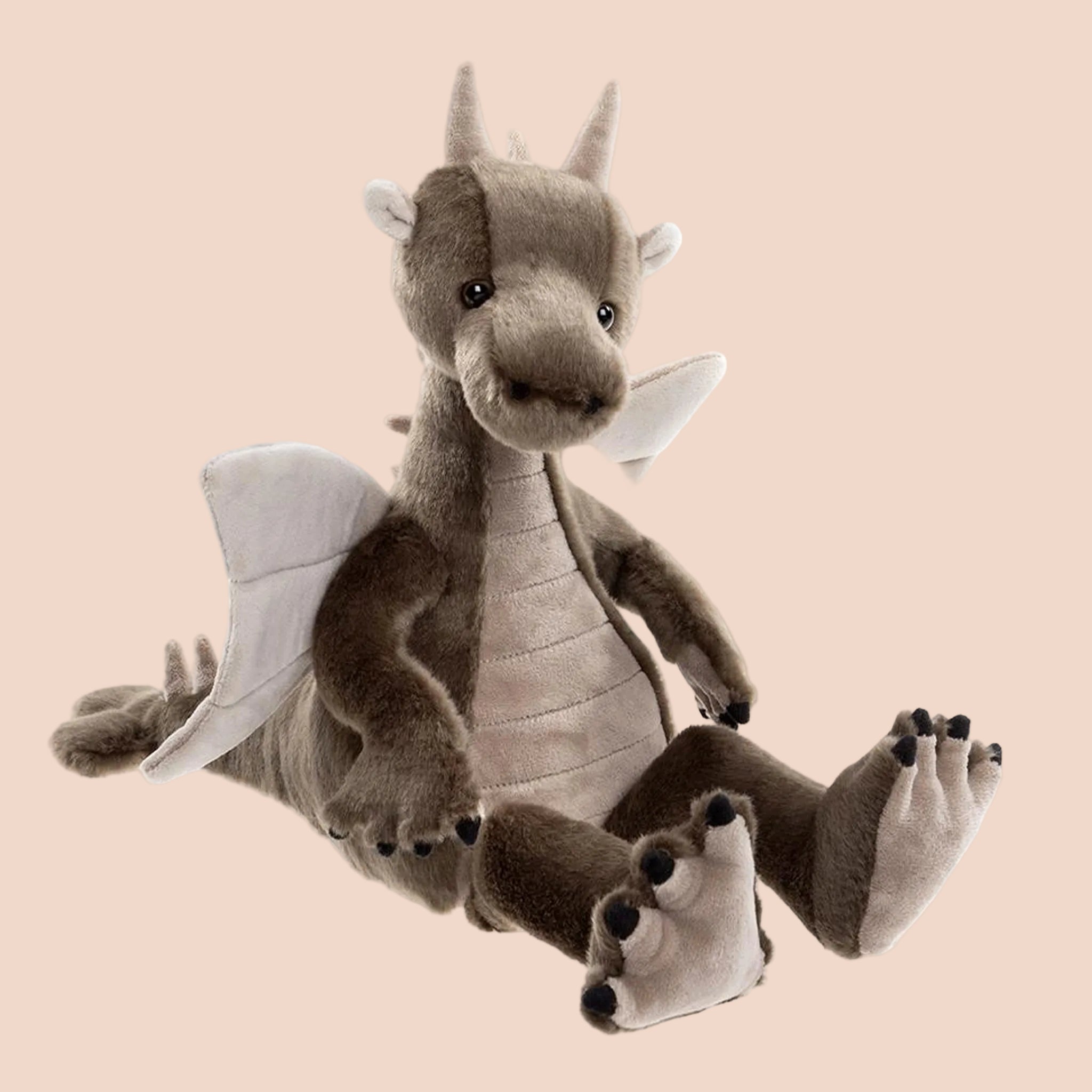 A greyish brown dragon shaped stuffed animal toy. 