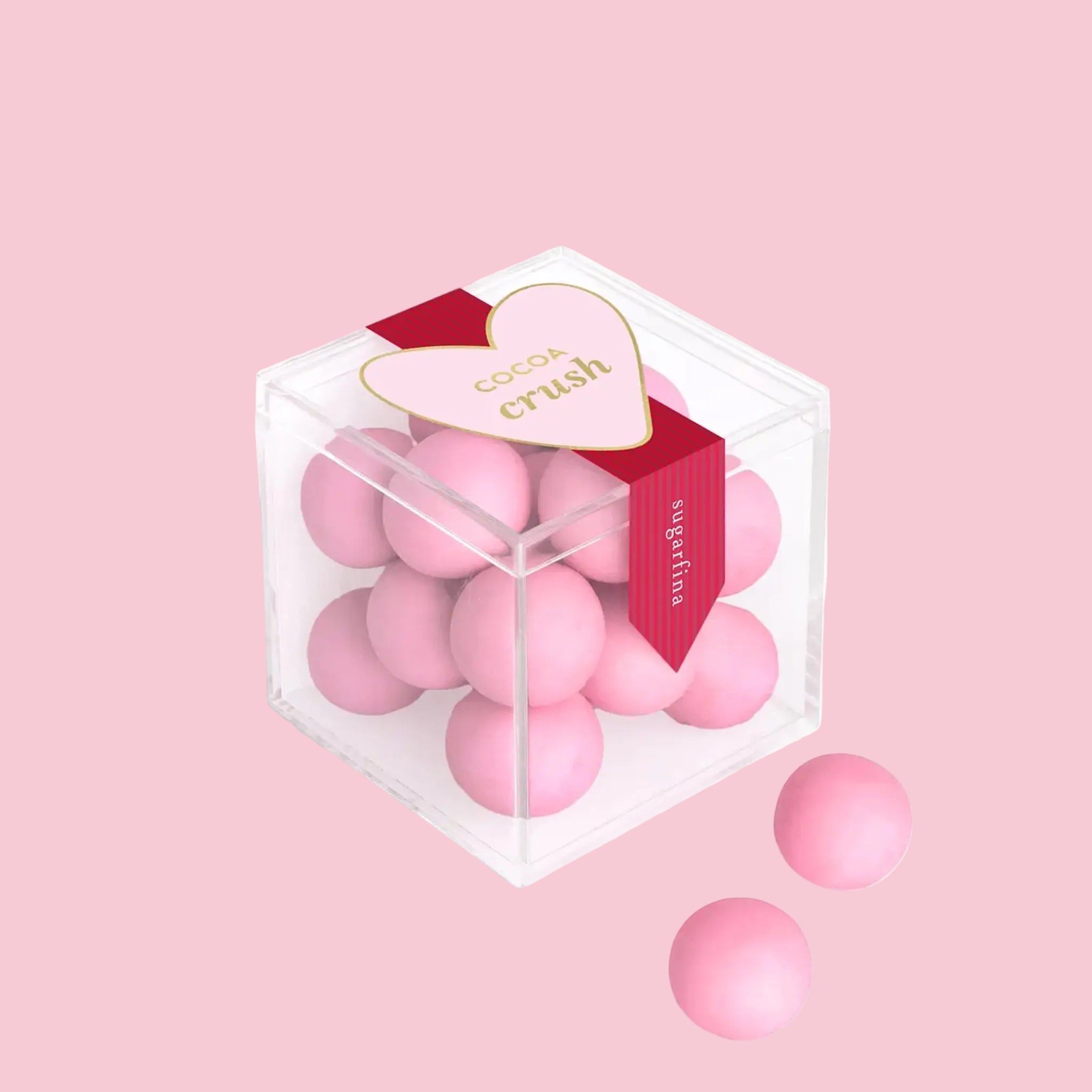 "cocoa crush" on an acrylic box of pink candies with a pink and dark pink label. 