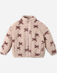 A fuzzy light pink jacket with a dark red bow pattern. 