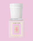 A white candle with a cool toned pink box with text that reads, 'Coconut Sugar Scented Candle'. 