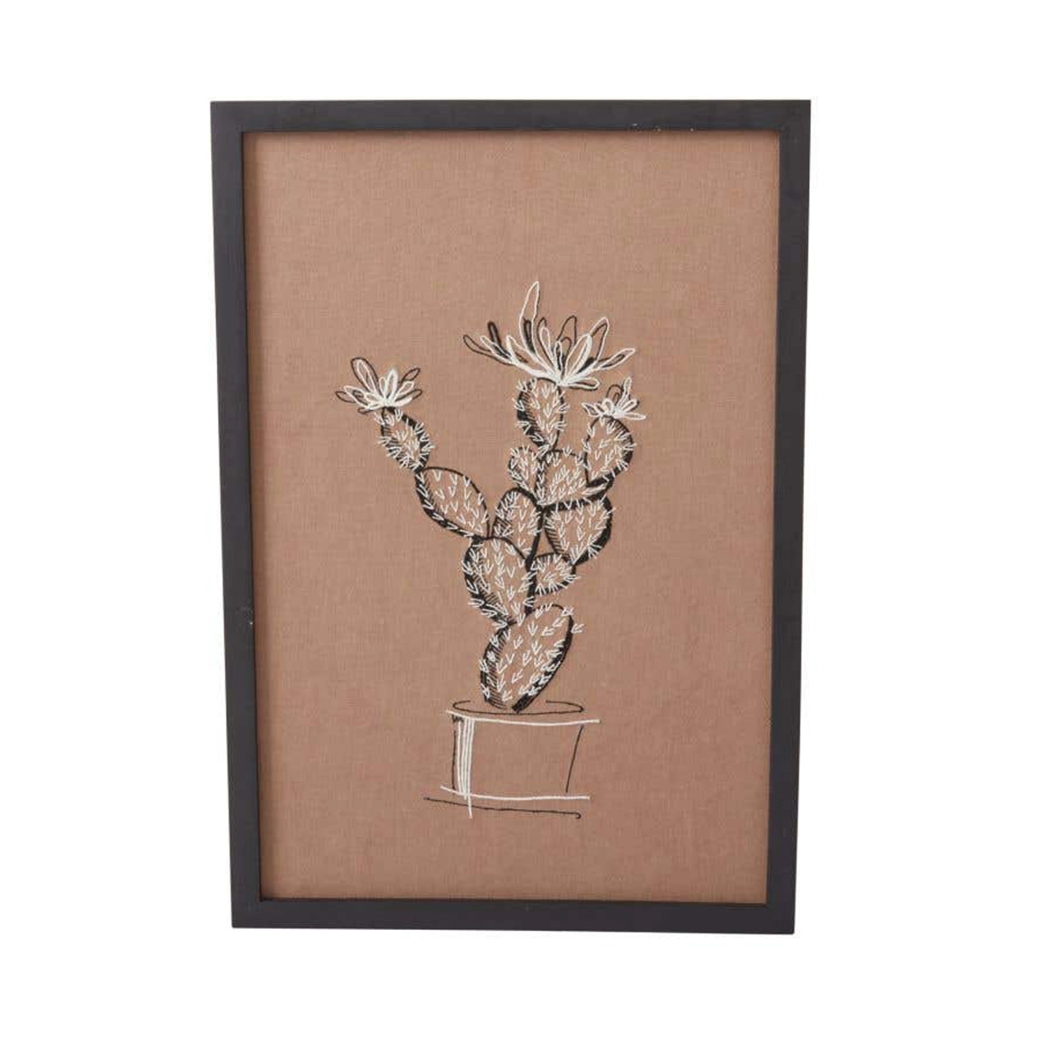 On a white background is a brown piece of wall art with white and black stitching of a cactus in a pot. The art comes in a simple black frame. 