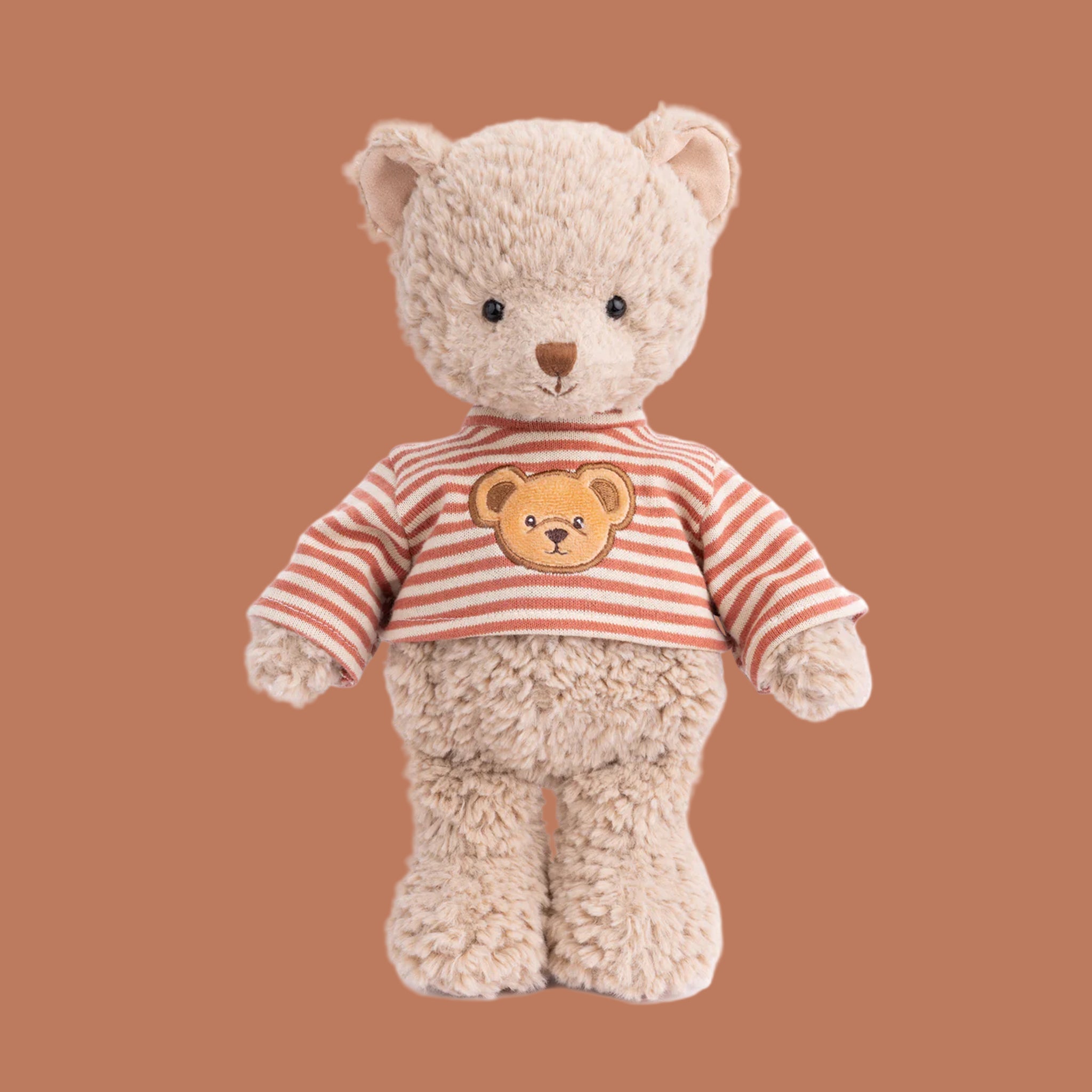 A bear shaped stuffed toy wearing a rust and ivory striped sweater. 