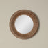 A round mirror with a border of hand woven natural jute. 