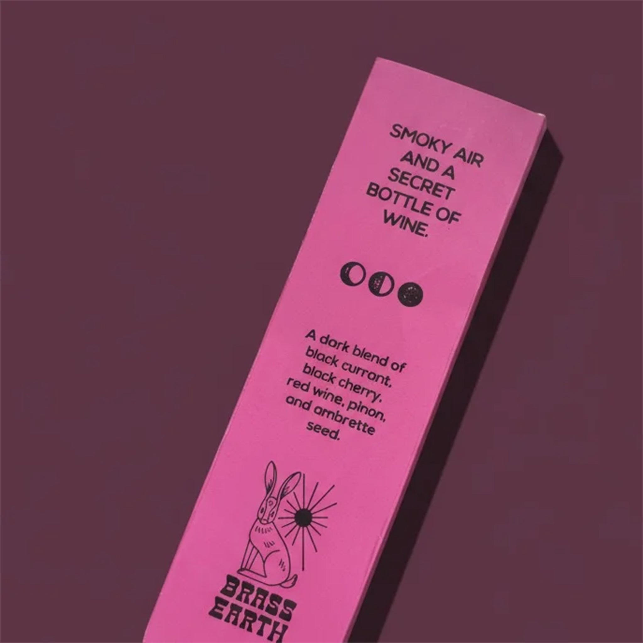 Pink packaging with text and branding on a dark purple background