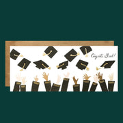 A card with a bunch of hands throwing up graduation caps along with text in the right corner that reads, "Congrats Grad!" as well as a coordinating gold envelope.