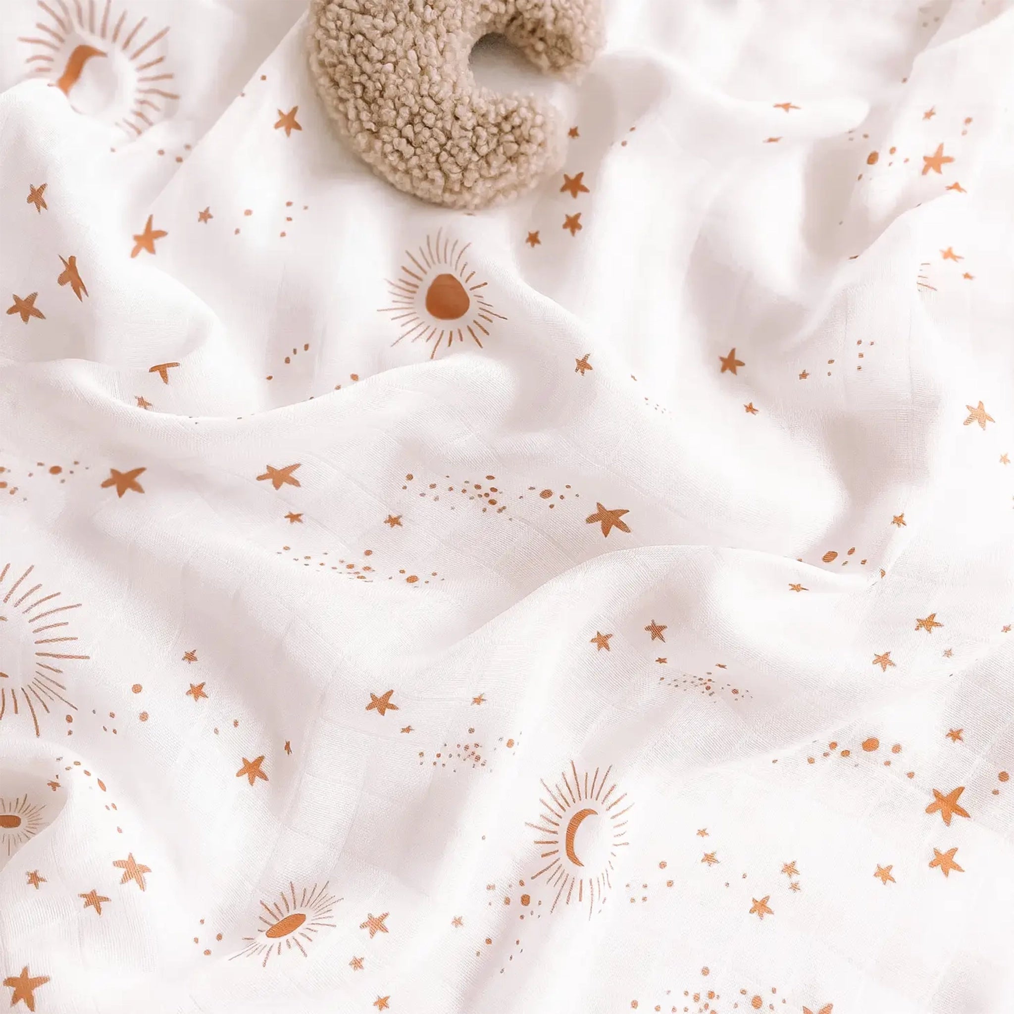 A neutral swaddle with a gold constellation print all over featuring moon and star designs.