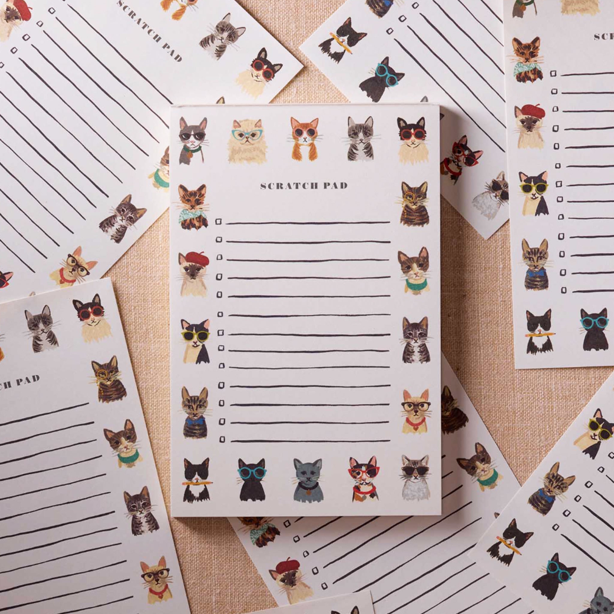 A white notepad with cat illustrations around the border and text in the center that reads, 'Scratch Pad' along with lines underneath and check boxes. 