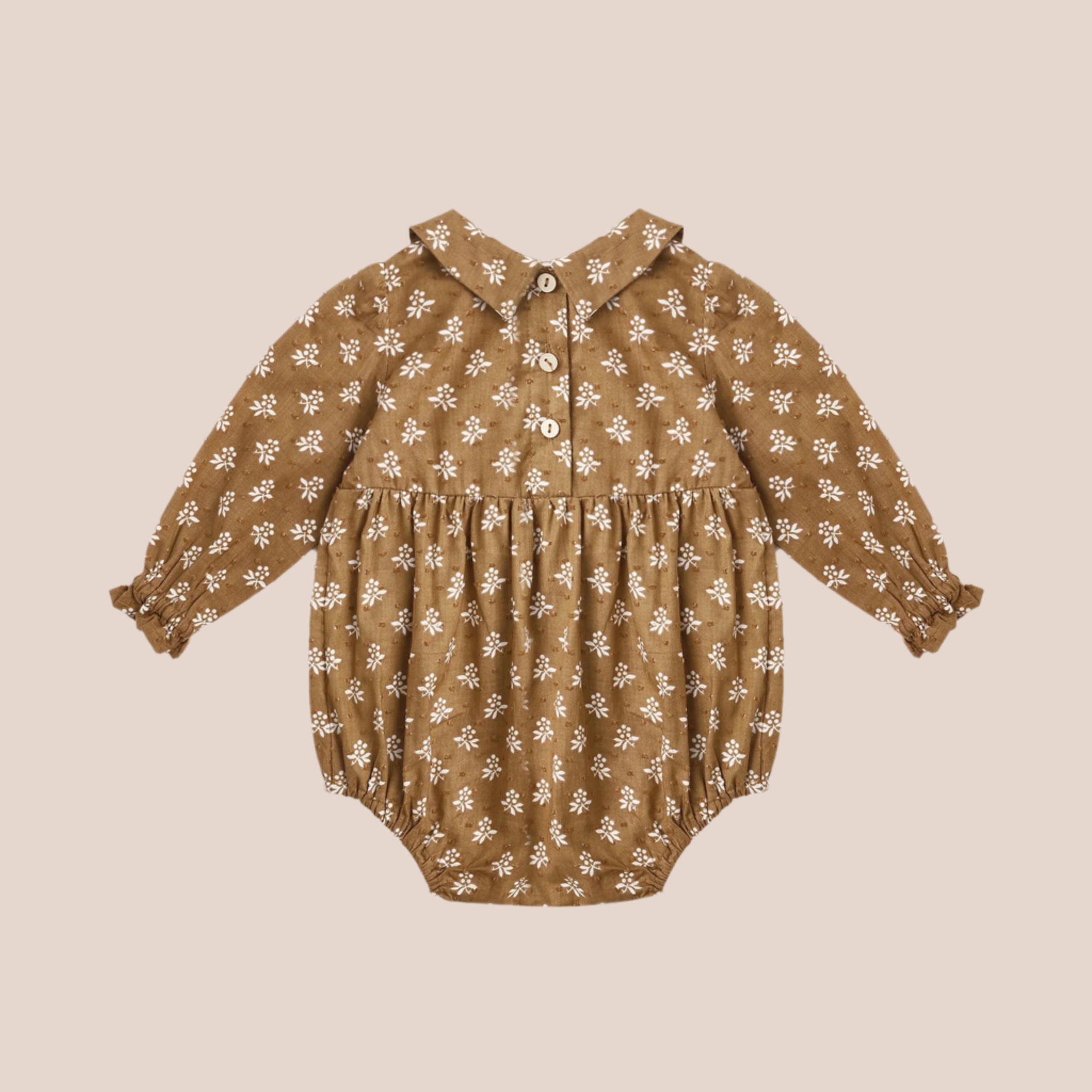 A golden brown romper with a collar and an ivory floral pattern. 
