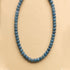 A blue beaded necklace. 