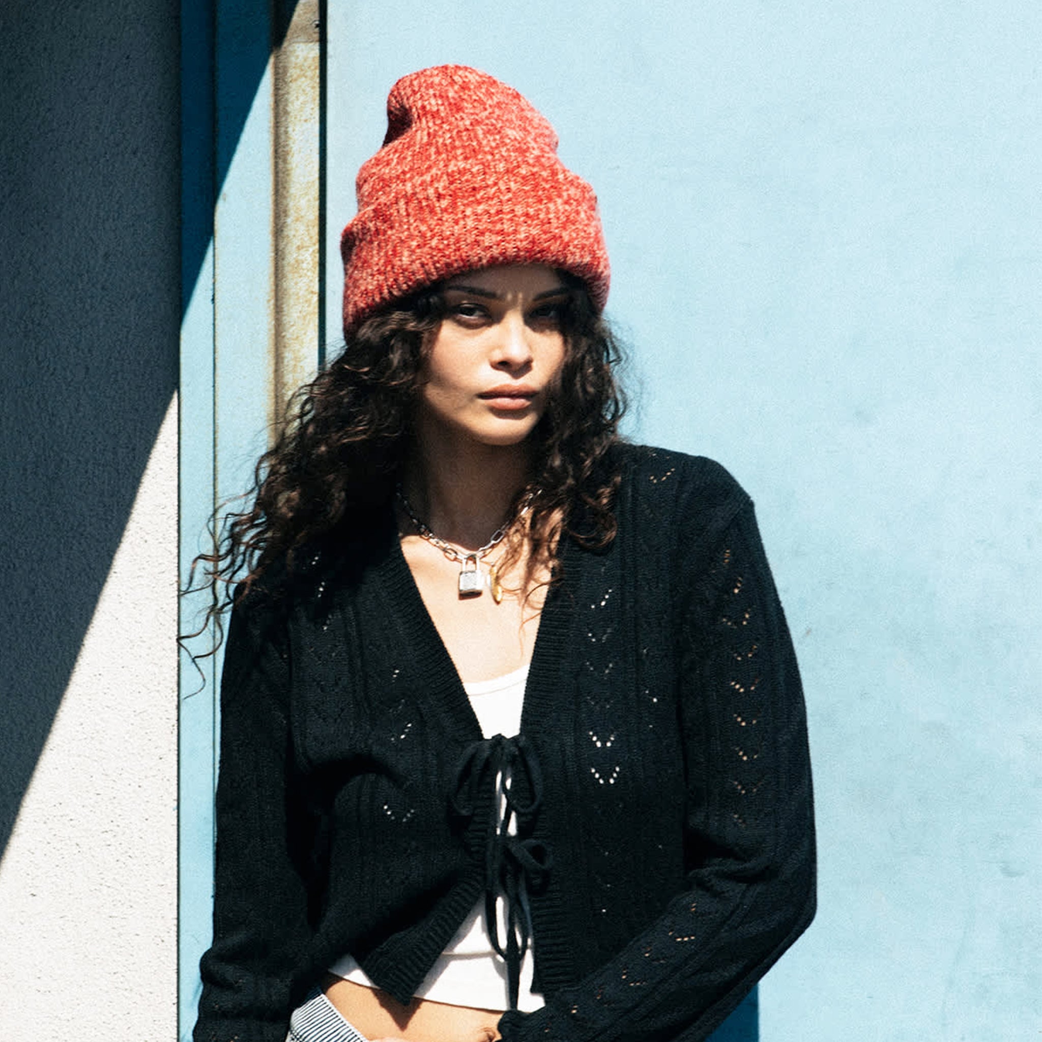 A red and peachy knit beanie. 