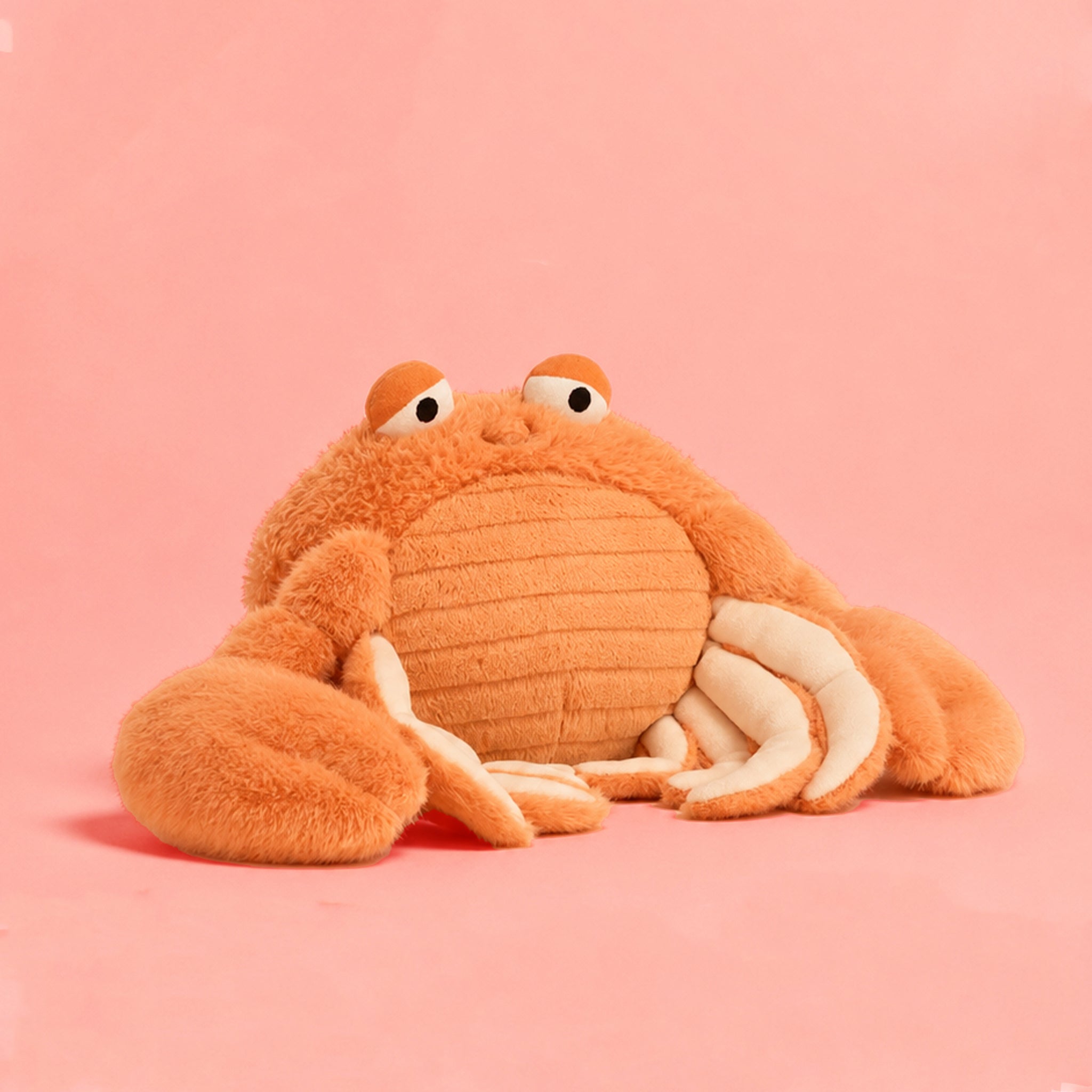 Plush crab toy on a pink background