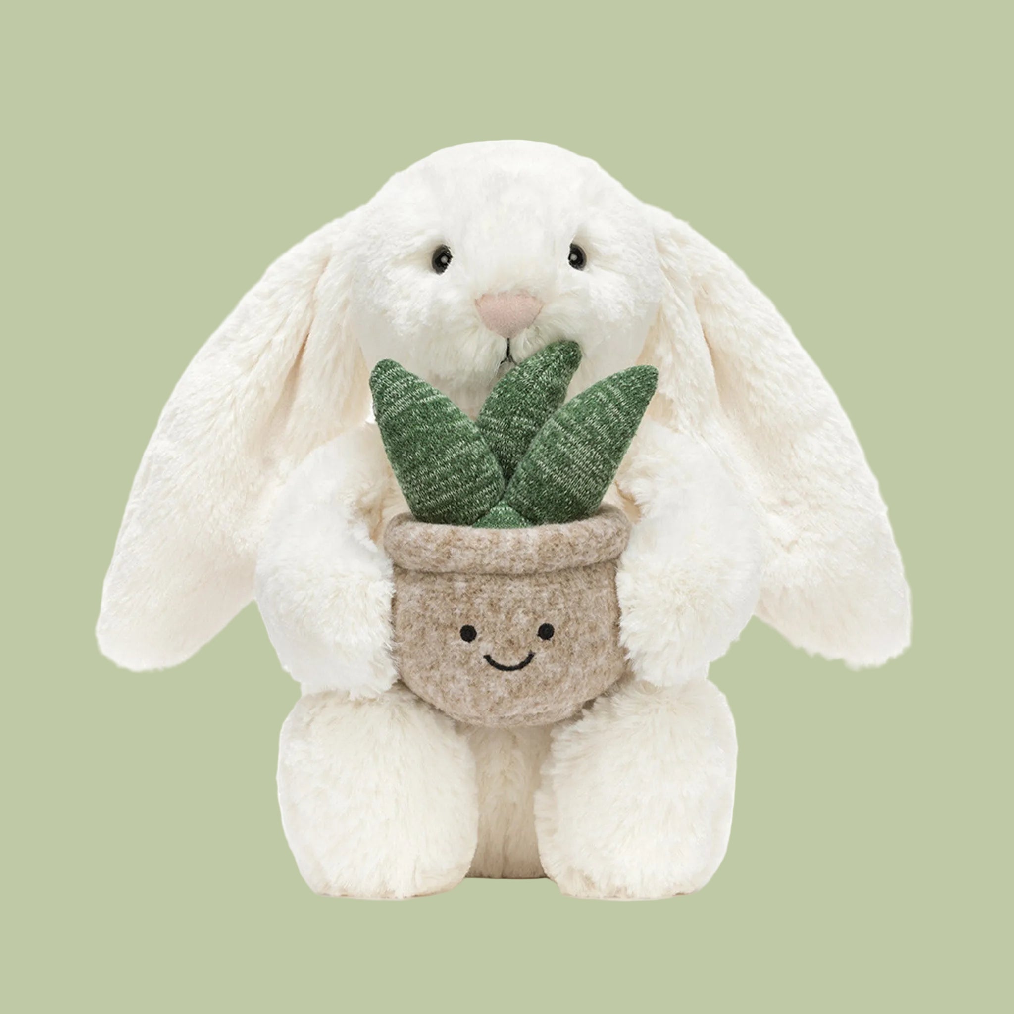 A cream colored bunny stuffed animal holding stuffed toy plant. 
