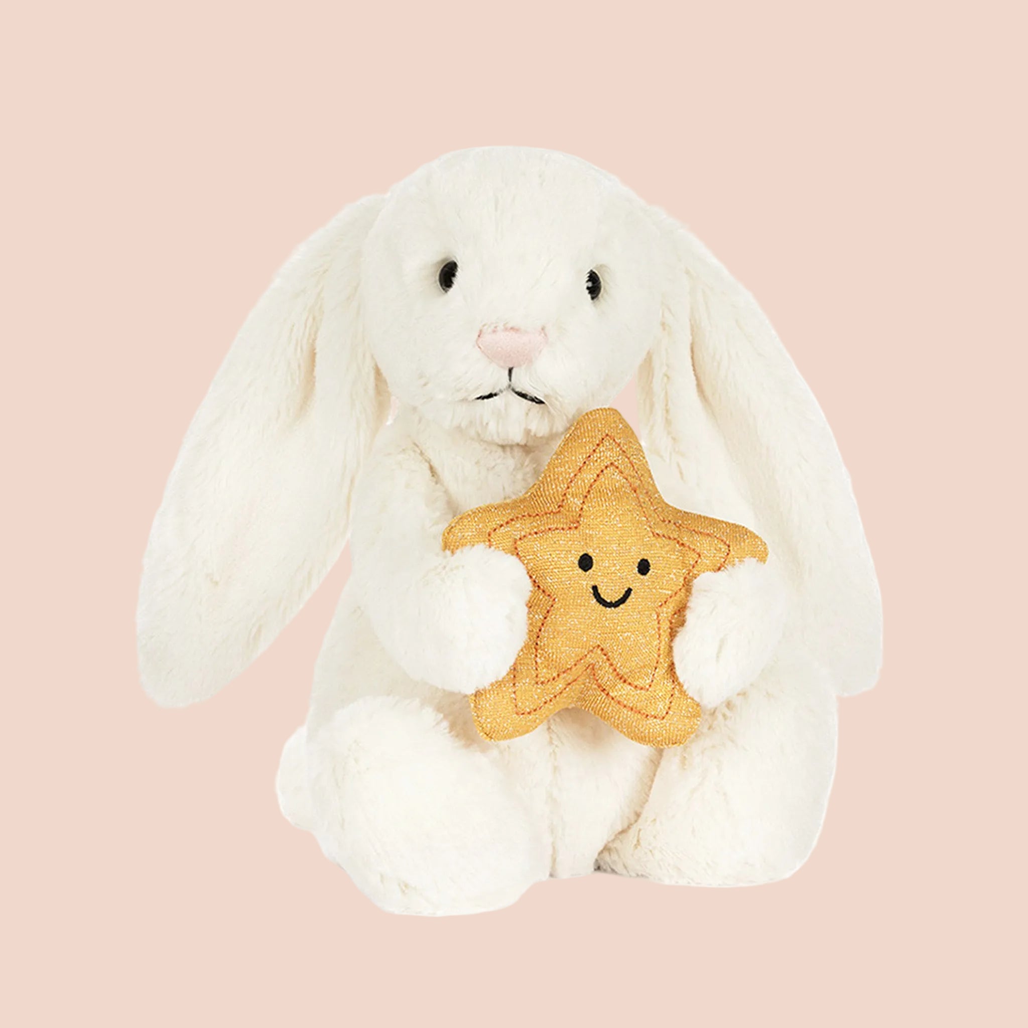 A cream colored bunny holding a star. 