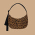 A medium sized crescent shaped bag with a leopard print and black adjustable strap. 