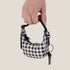 A black and white crescent shaped bag charm. 