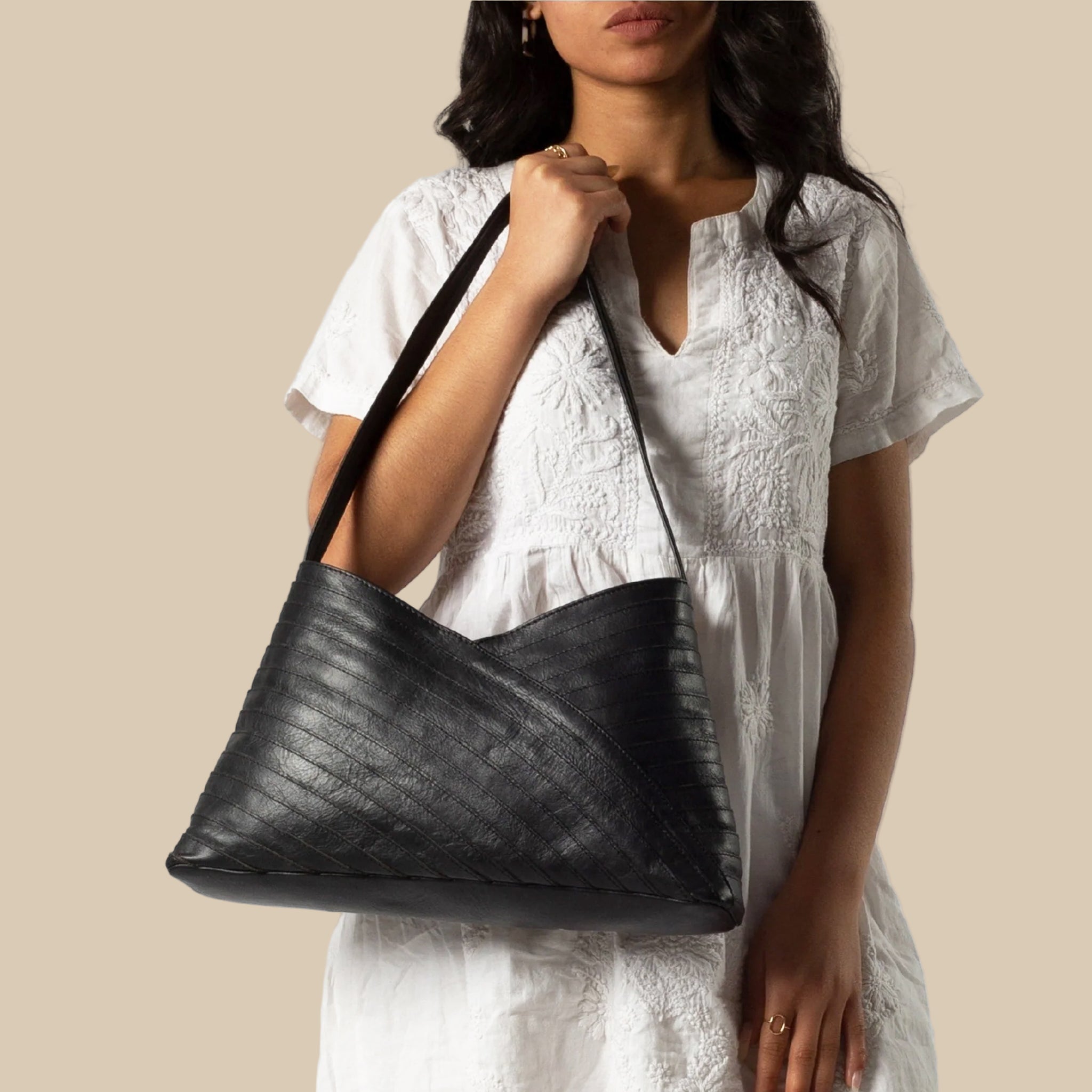 A black crisscross designed shoulder handbag. 