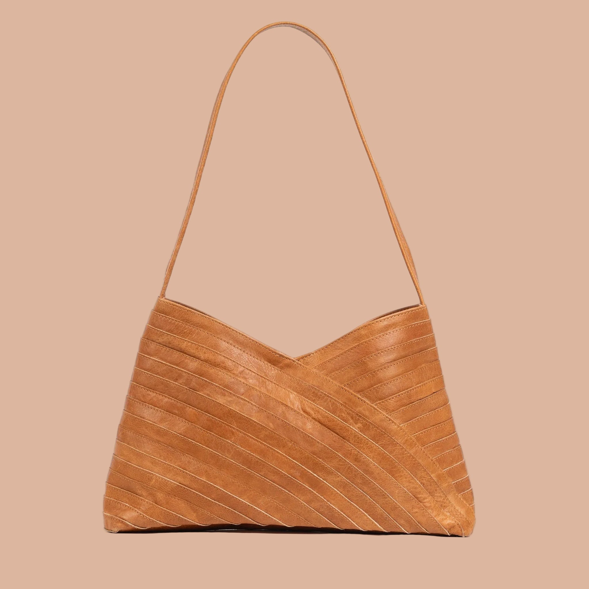 A crisscross designed shoulder handbag in a neutral camel color. 