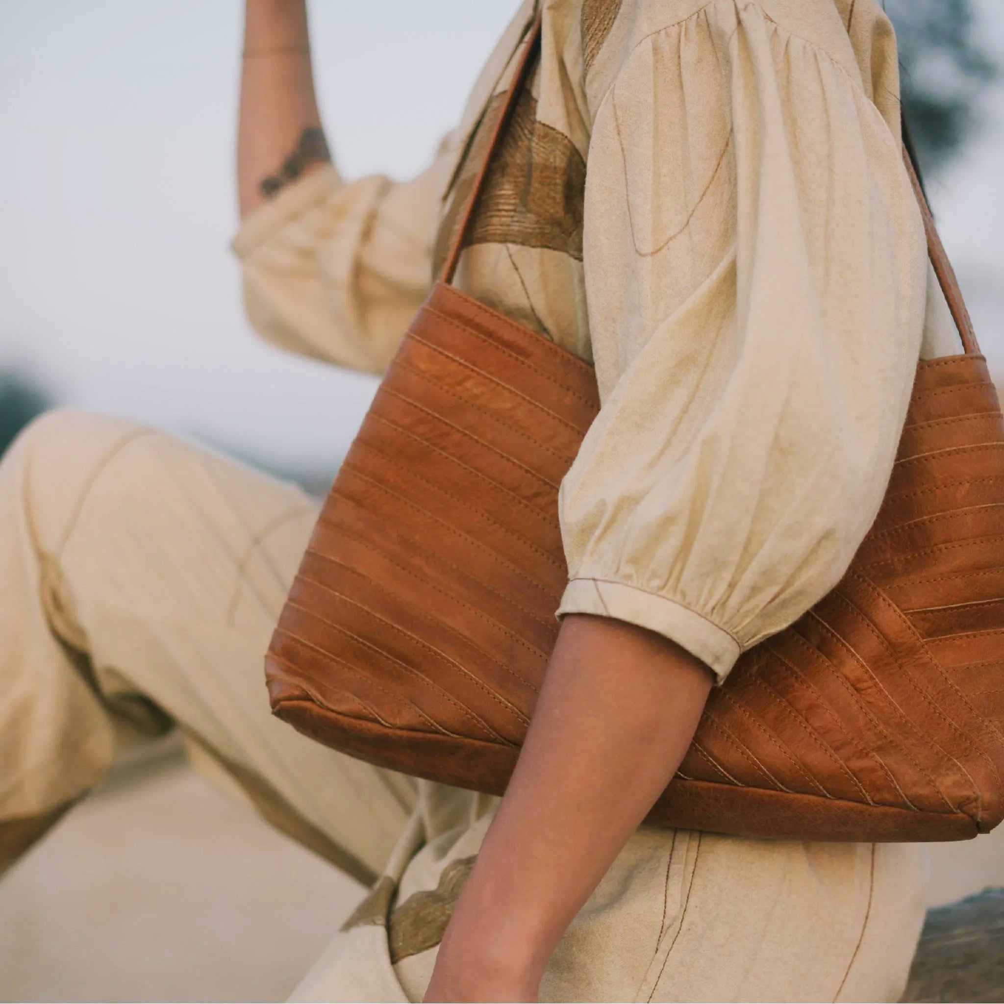 A crisscross designed shoulder handbag in a neutral camel color. 