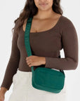 A green crossbody bag made of nylon with an adjustable strap.