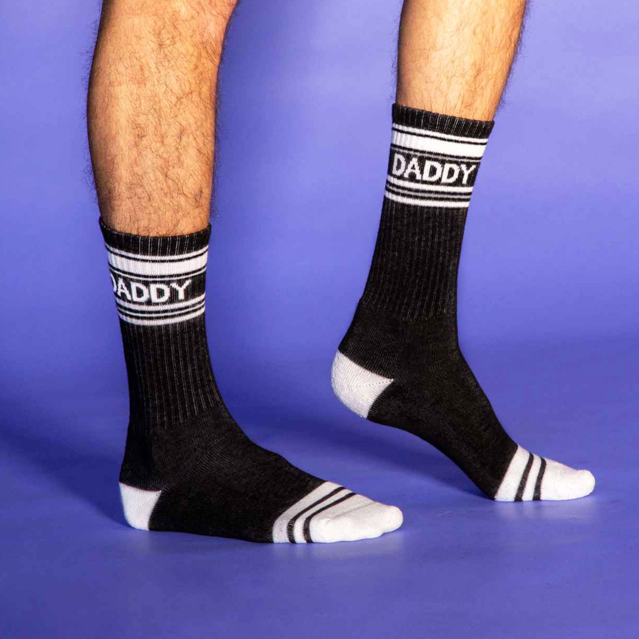 A pair of black and white crew socks that are ribbed with text across the top that reads, &quot;Daddy&quot;. 
