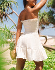 A cream smocked mini strapless dress. 