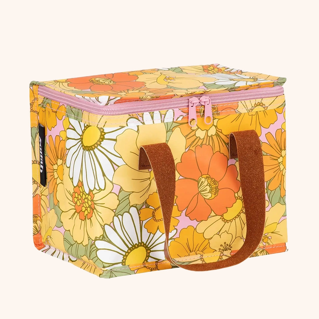 a yellow, orange and white floral patterned lunch box with brown leather straps and a double zipper opening.