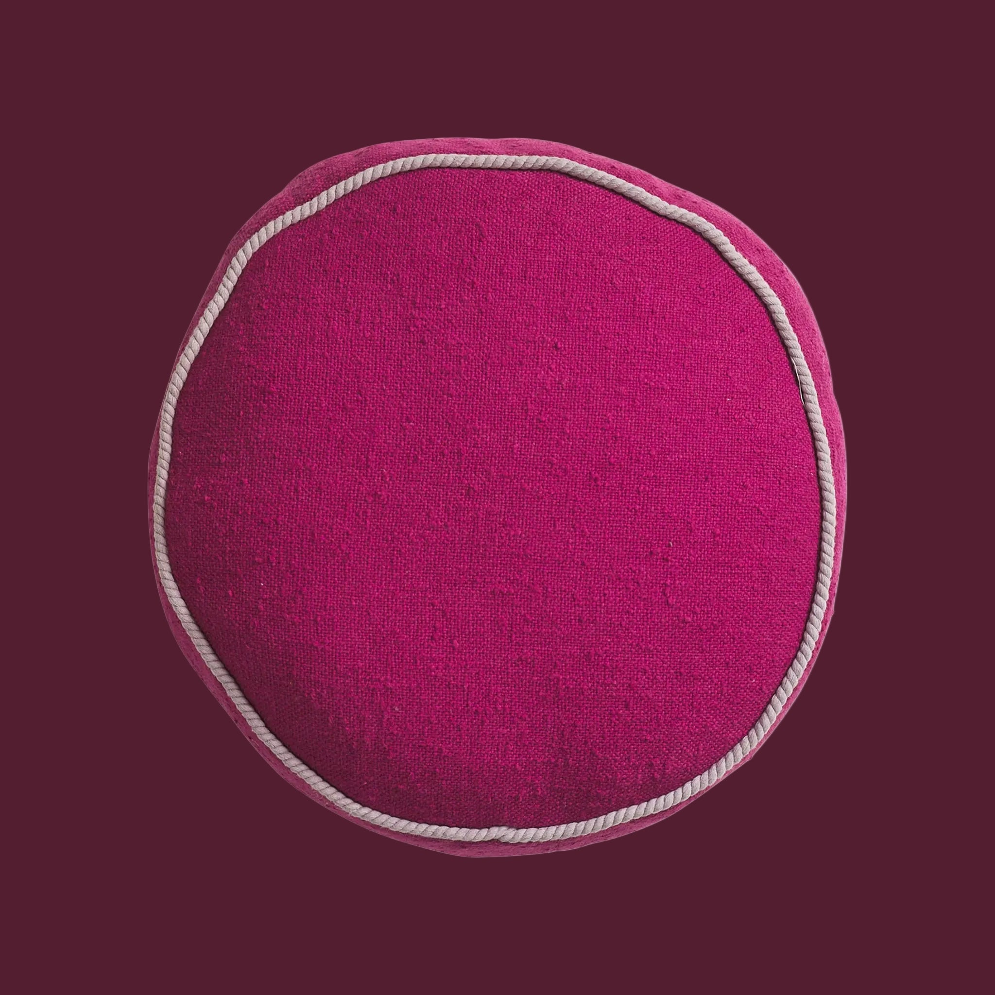 A round plum colored cushion. 