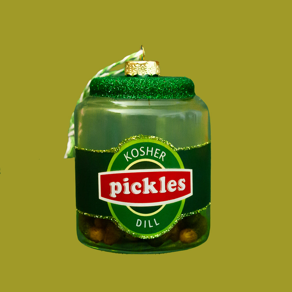 Decorative ornament shaped like a jar of kosher dill pickles on a green background