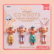 On a peach background is four drink markers in the shape of cowboys with different colored chaps and hats on. 