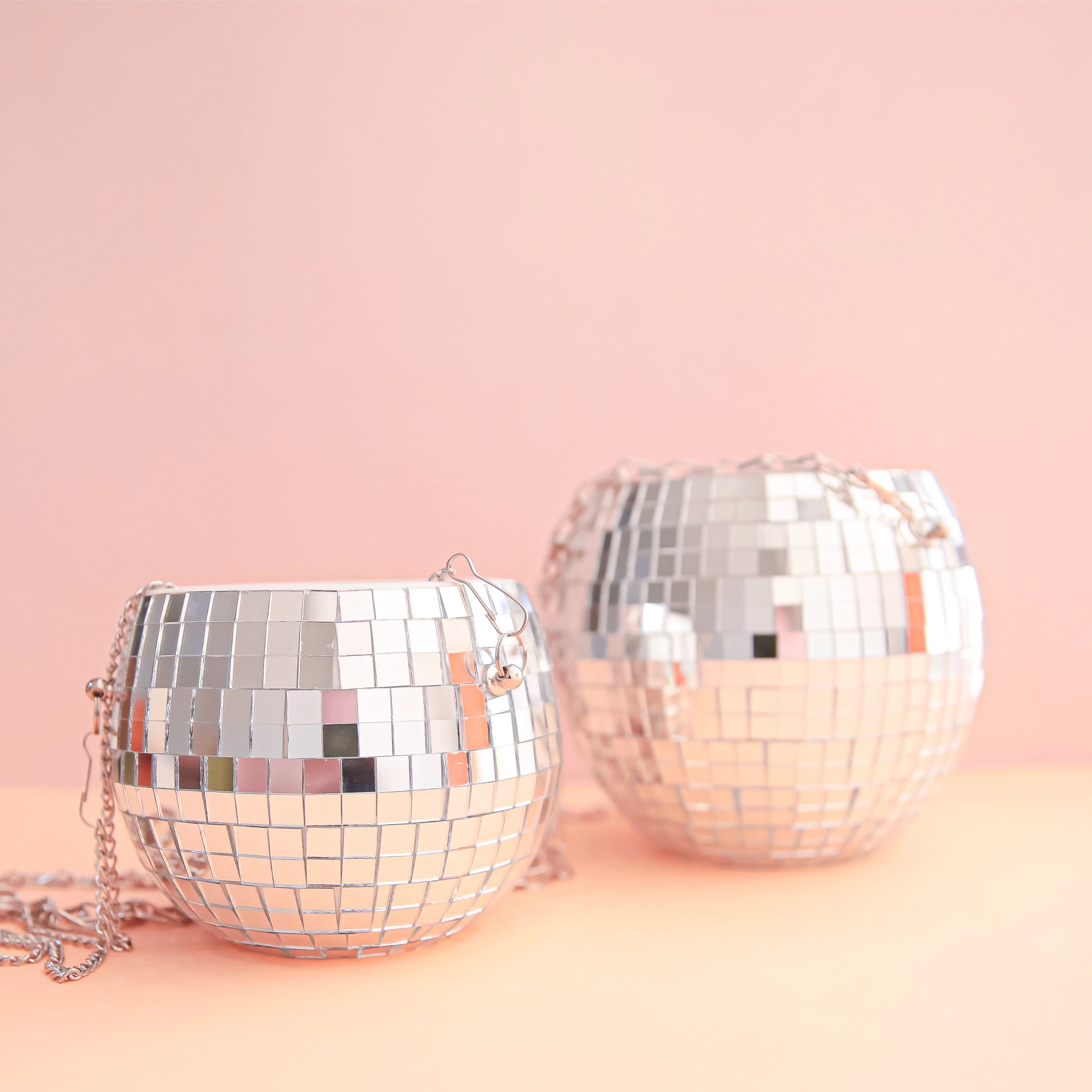 On a soft pink background is the two available sizes of the hanging disco ball planter. 