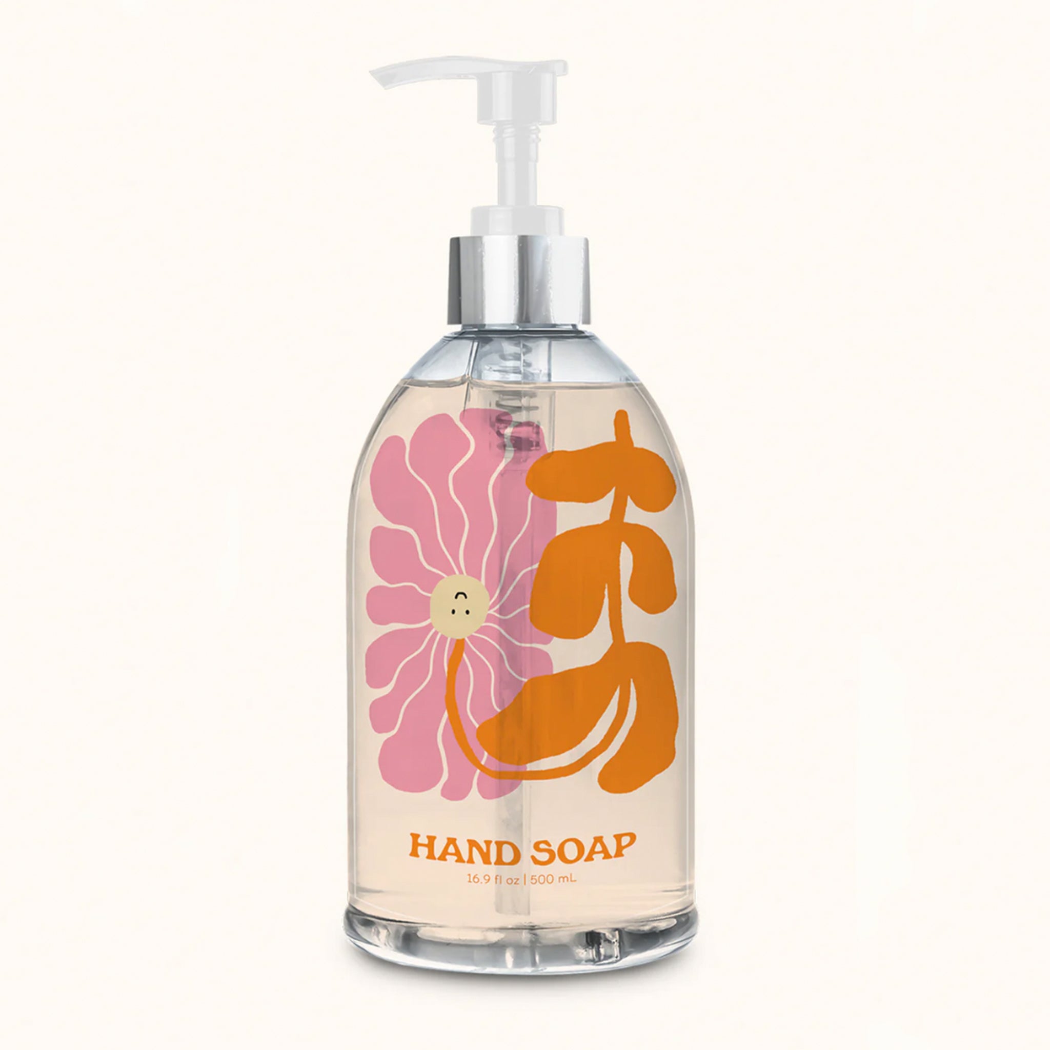 On an ivory background is a clear bottle of hand soap with a pink and orange floral illustration on the front with a pump and text along the bottom that reads, &quot;Hand Soap&quot;. 