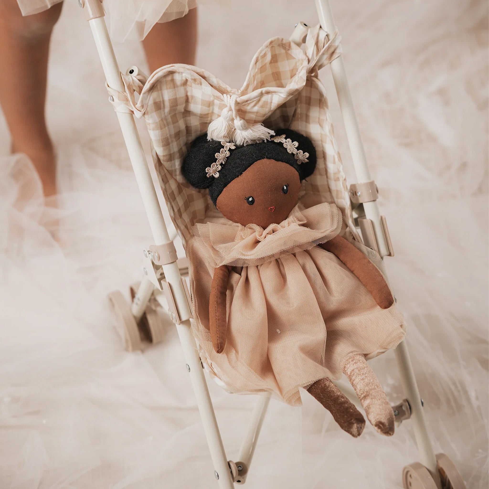 Miniature doll stroller with checkered seat cover on a white background