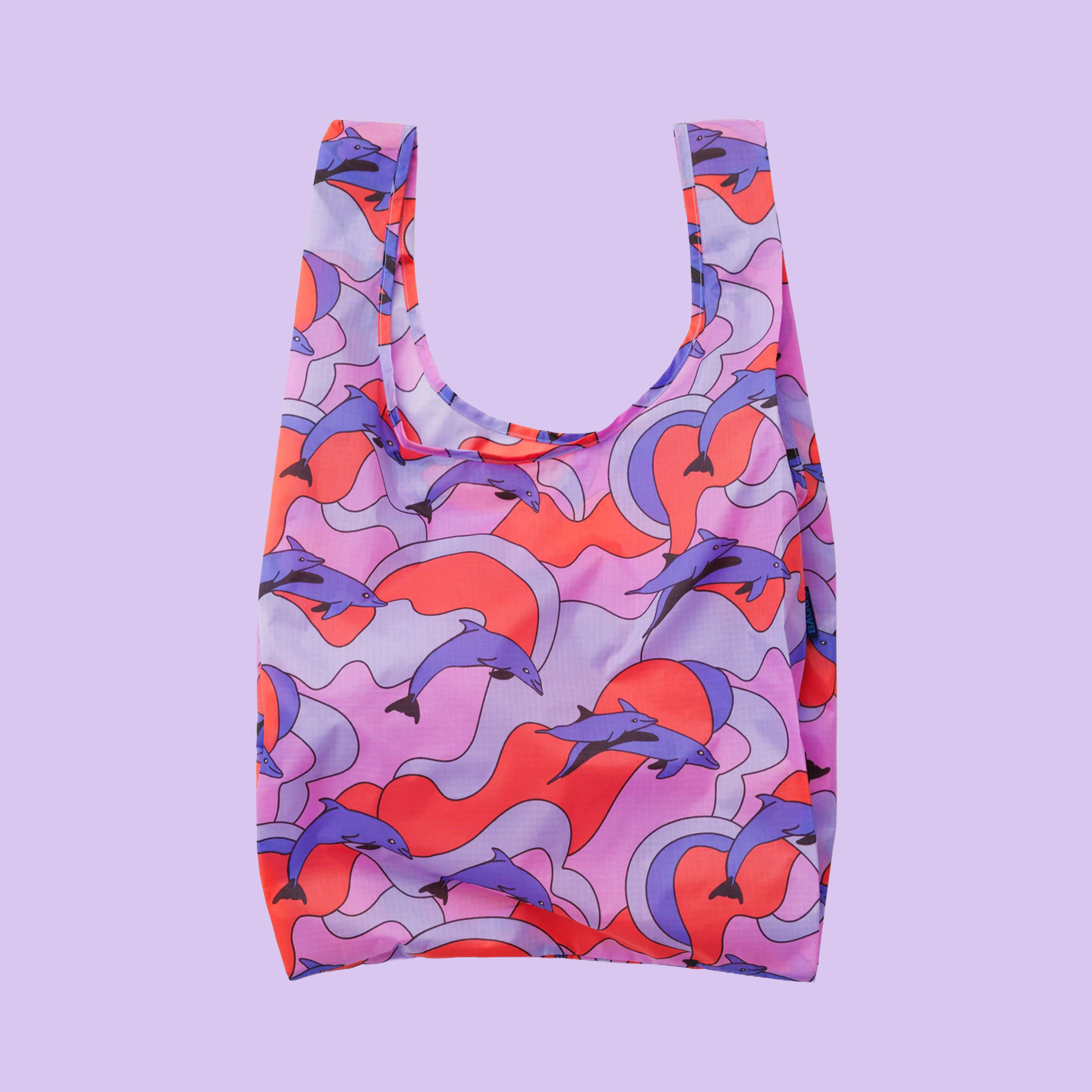 A reusable bag with red, pink and purple dolphins and details on a lavender background.