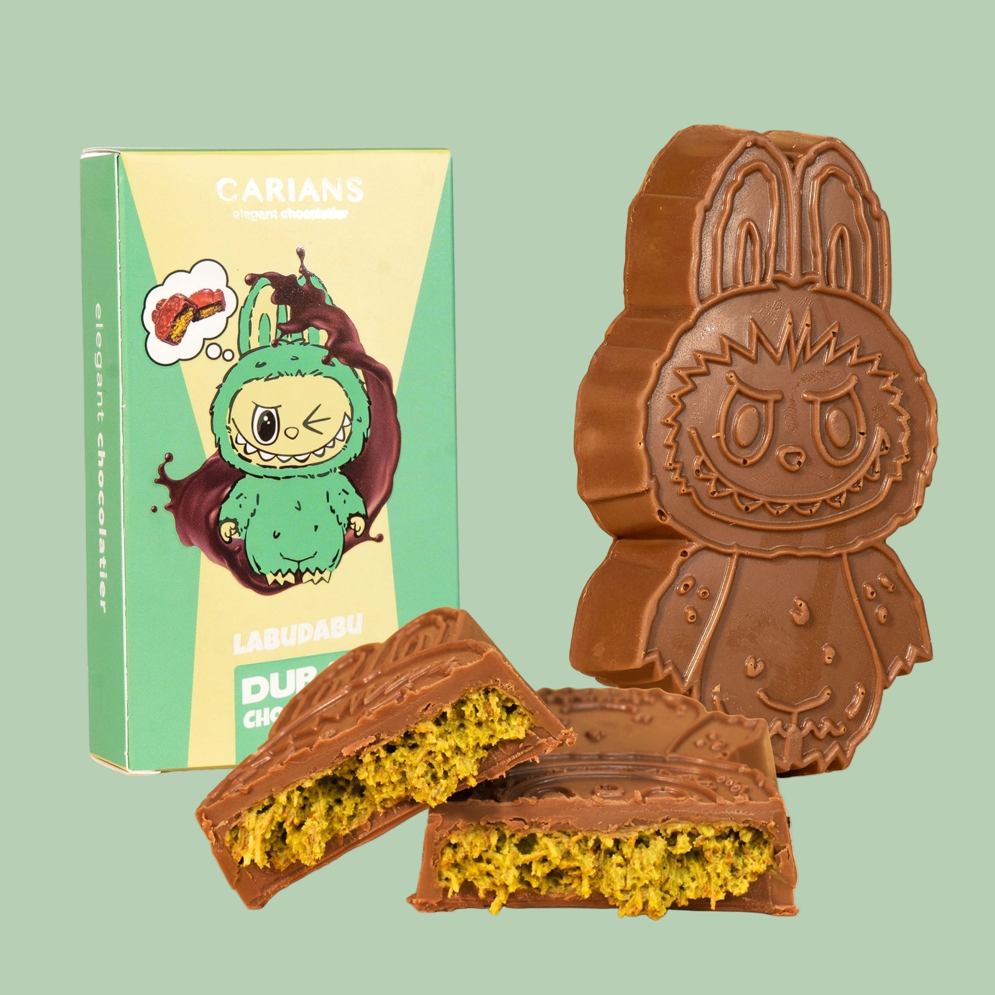 A green and yellow box filled with a Labubu shaped chocolate bar. "Carian's Labudabu Dubai Chocolate". 