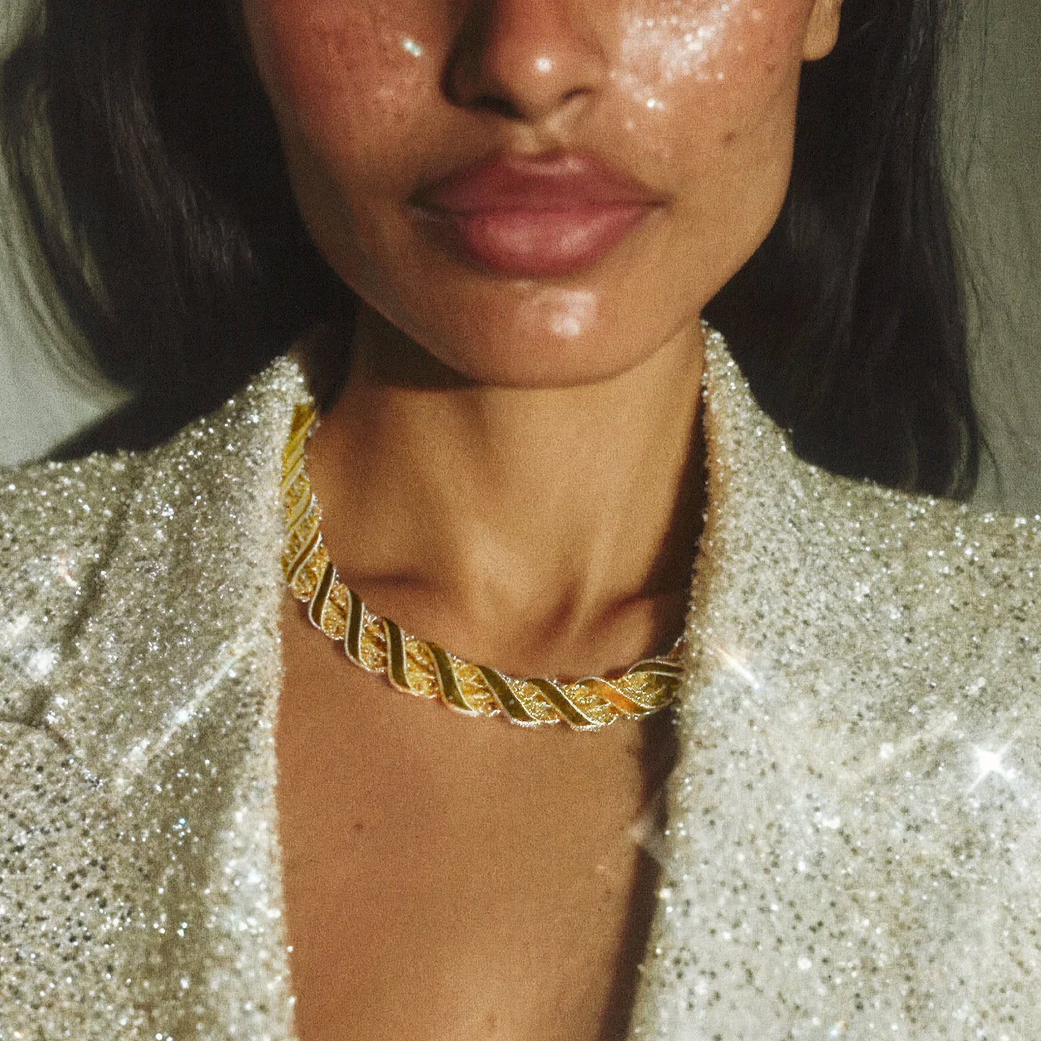 A gold statement necklace with a twisted rope detail. 