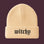 A cream-colored ribbed knit beanie hat with the word 'witchy' embroidered in a black gothic font on the front cuff, set against a solid pale peach background.