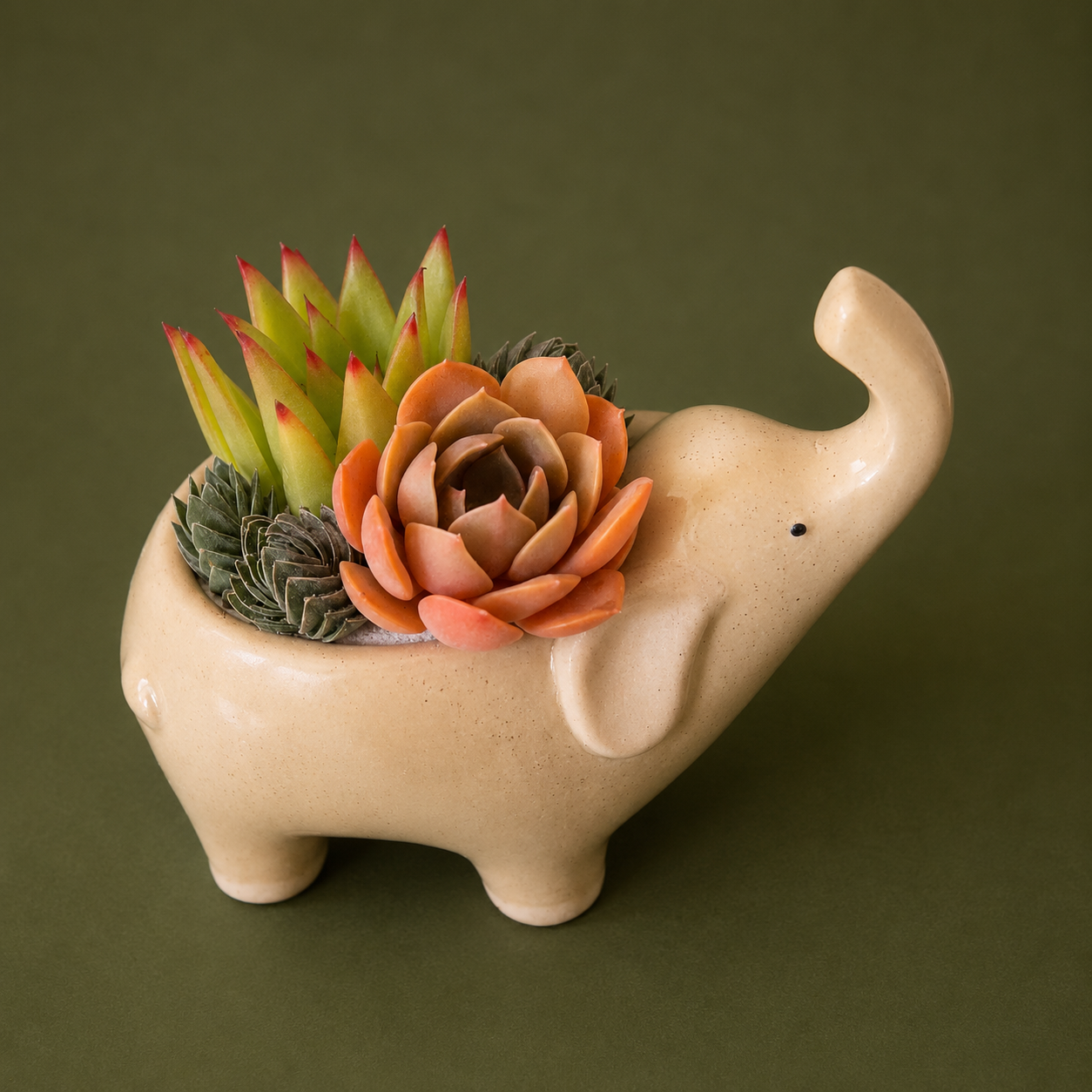 A ceramic elephant with its nose in the air.  The ceramic is a tan color with speckles.