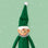 Green elf ornament on a mint green background with white stars. 