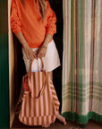 A pink and orange vertical striped canvas tote bag. 