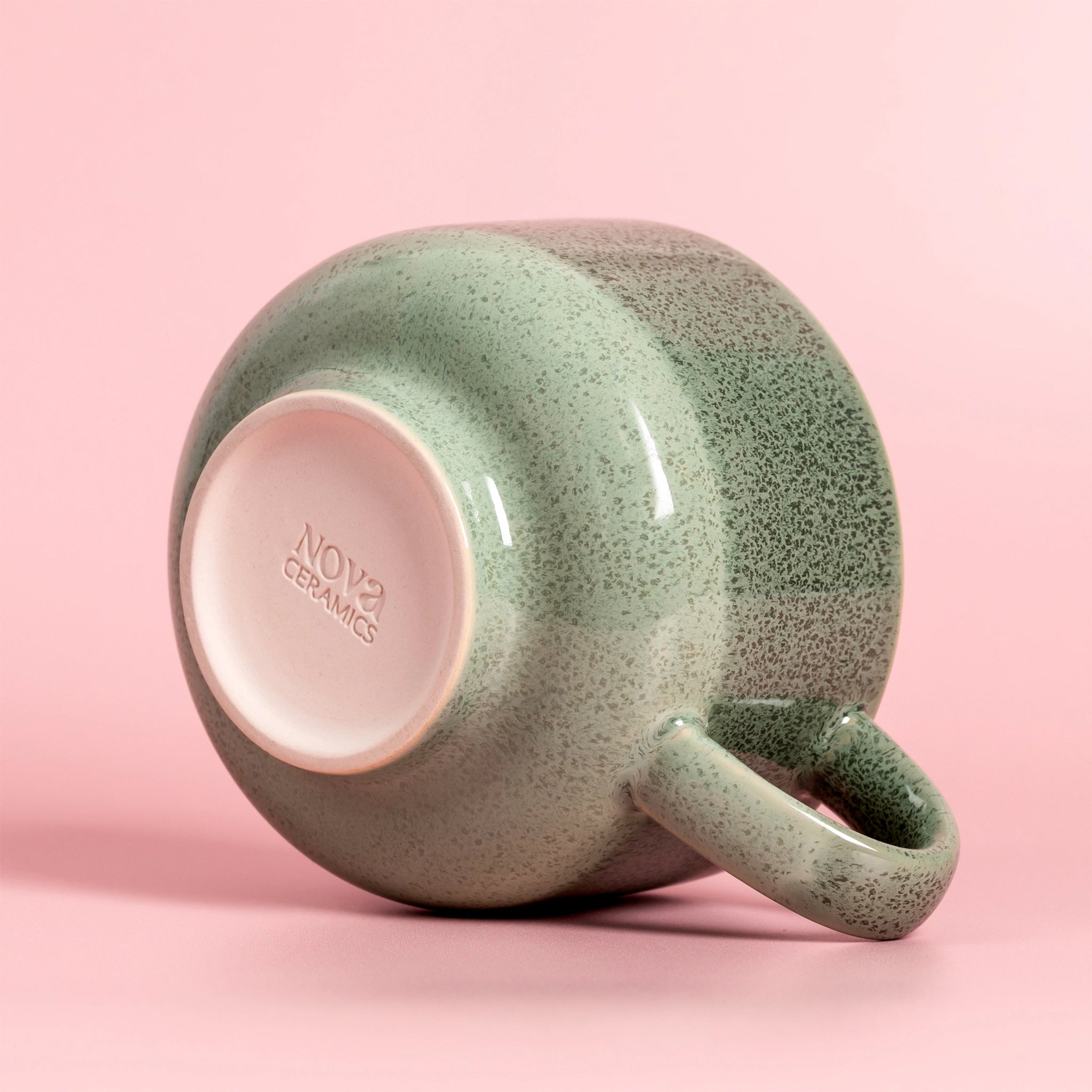 A green speckled ceramic mug. 